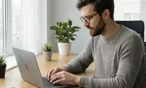 мужчина в очках работает за ноутбуком